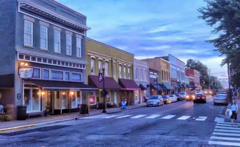 People walking and driving in downtown, historic Apex, North Carolina.