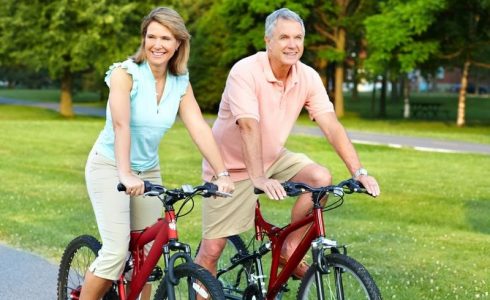 Older couple biking on path