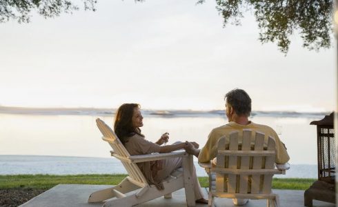 couple sitting outdoors on porch by lake