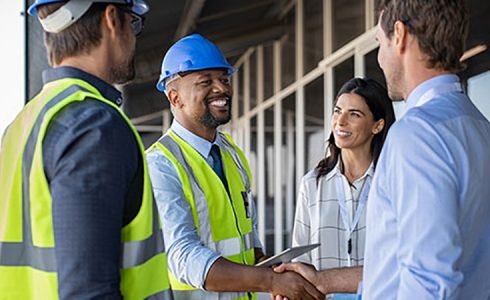 Home Construction man in hard hat shaking hands with customer