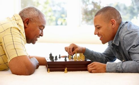 older and younger man playing chess
