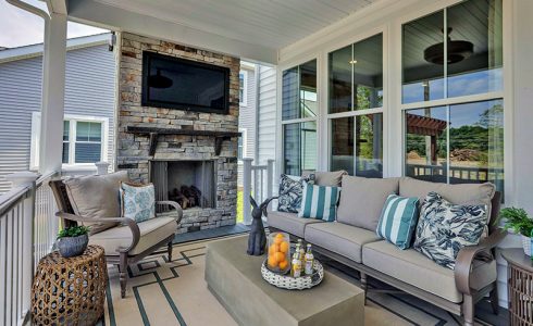 porch with outdoor fireplace in the cove at giles farm by HHHunt Homes