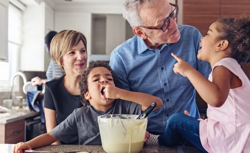 parent and grandparent with children baking in kitchen