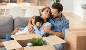 Family smiling sitting on floor with moving boxes